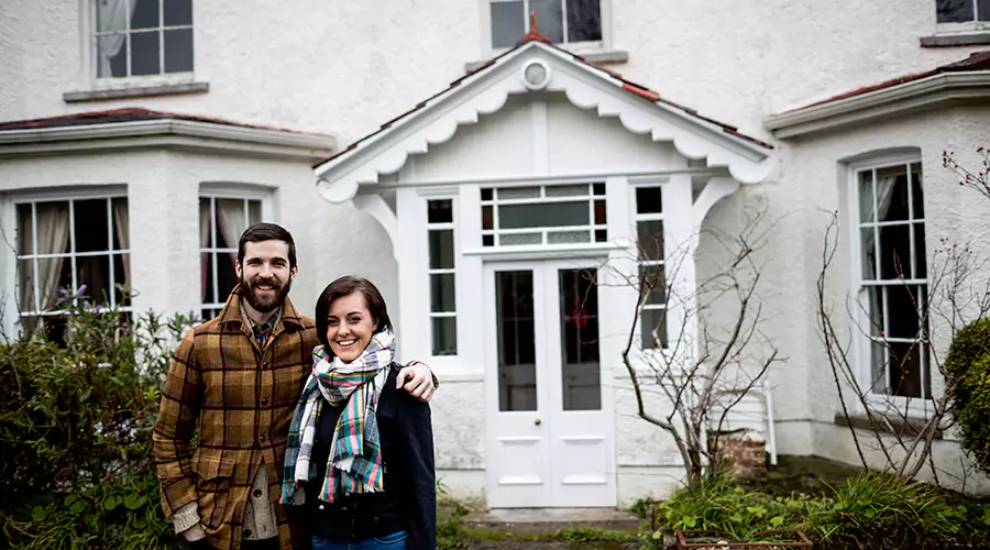 Homeowners standing outside their home after mold remediation service